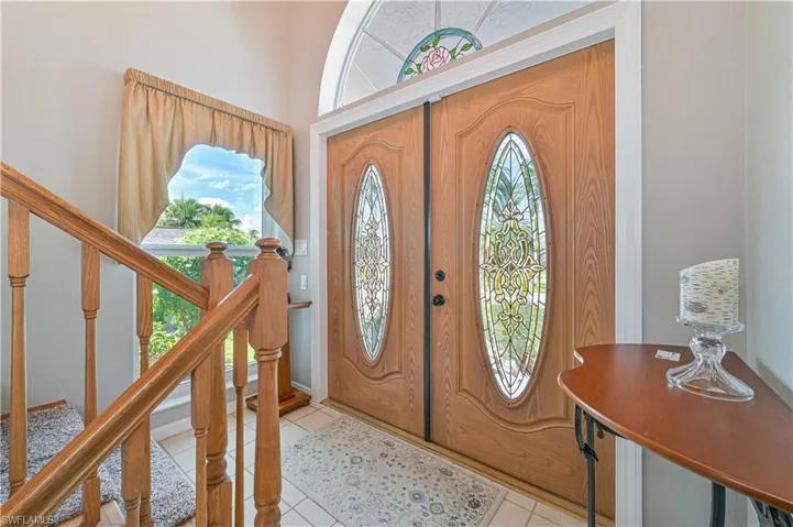 Foyer entrance with light tile patterned flooring