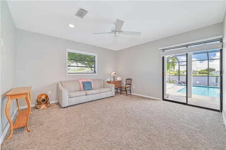 Carpeted living room with ceiling fan