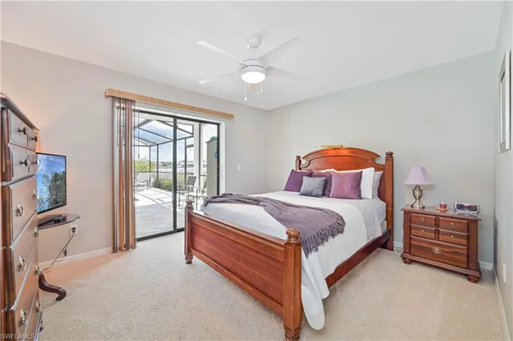 Bedroom featuring light carpet, ceiling fan, and access to outside