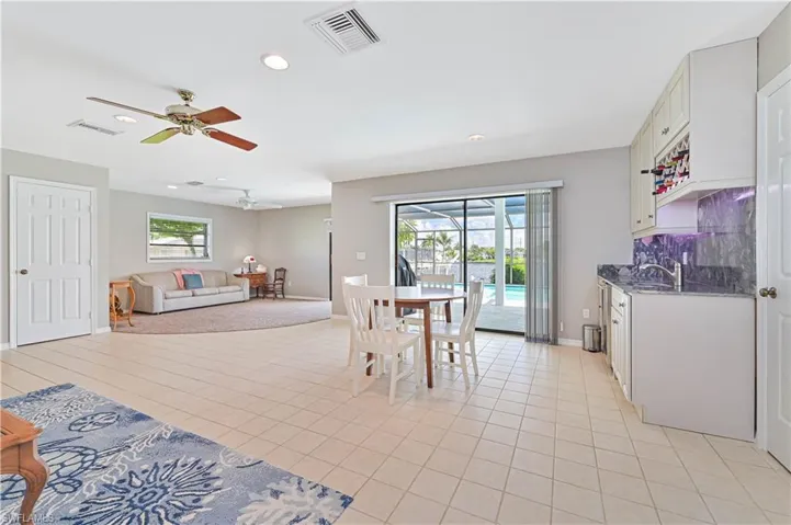 Tiled dining area with a healthy amount of sunlight, ceiling fan, and sink
