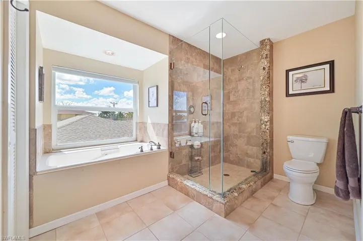 Bathroom featuring tile patterned flooring, toilet, and shower with separate bathtub