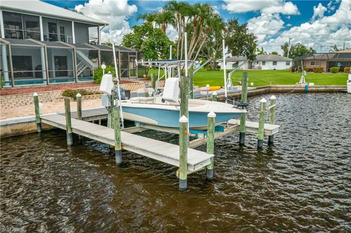Dock area featuring a water view, a yard, and a lanai