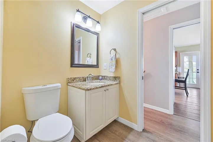 Bathroom with vanity, toilet, and hardwood / wood-style flooring