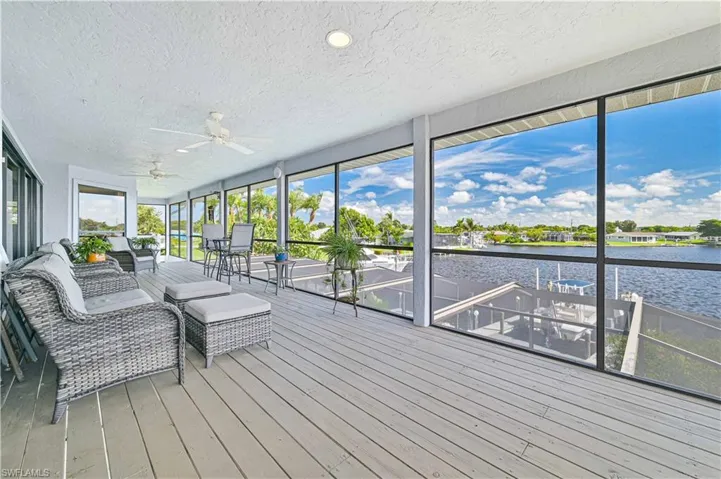 Unfurnished sunroom featuring ceiling fan and a water view