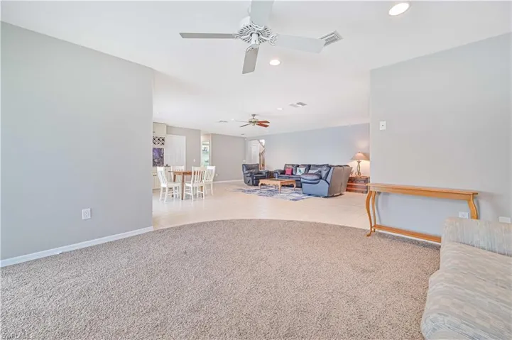 Living room with light colored carpet and ceiling fan