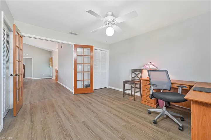 Home office featuring light wood-type flooring, french doors, and ceiling fan
