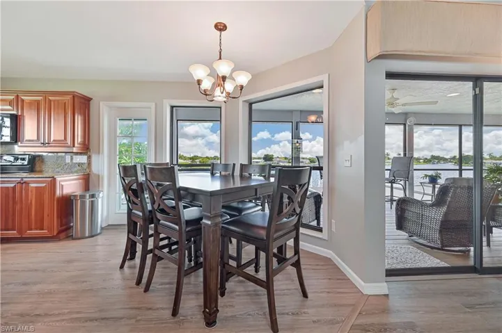 Dining space featuring light wood-type flooring and ceiling fan with notable chandelier