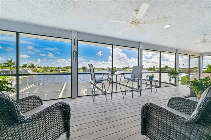 Sunroom with a water view and ceiling fan