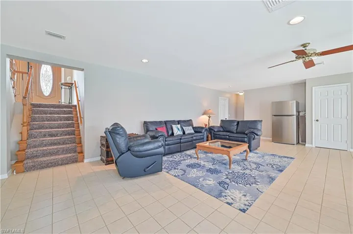 Living room with ceiling fan and light tile patterned floors