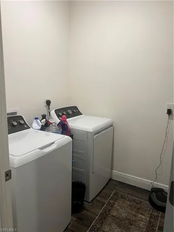 Dedicated laundry area featuring wood-finish flooring and neutral wall tones