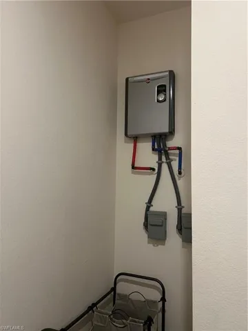 Wall-mounted tankless water heater with visible plumbing and electrical connections