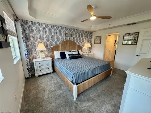 Bedroom with carpet flooring, ornamental molding, baseboards, a raised ceiling, and wallpapered walls