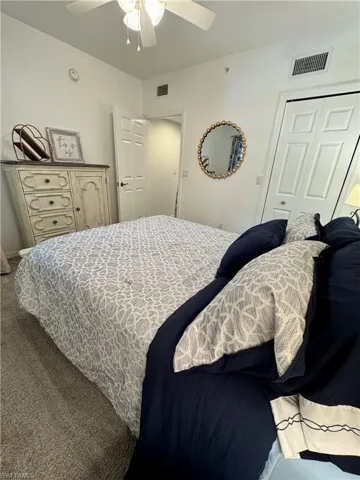 Bedroom with carpet, a closet, ceiling fan, and visible vents
