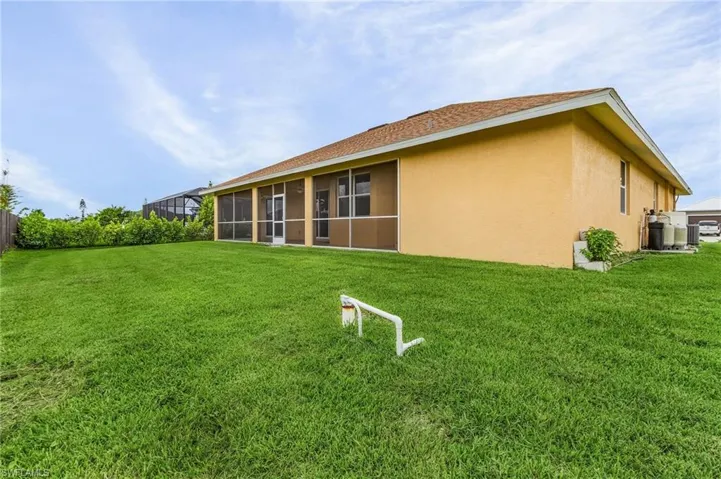 Back of house featuring a lush lawn,