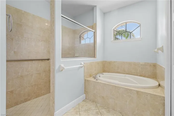Master bathroom featuring walk-in shower and separate step-up tub.