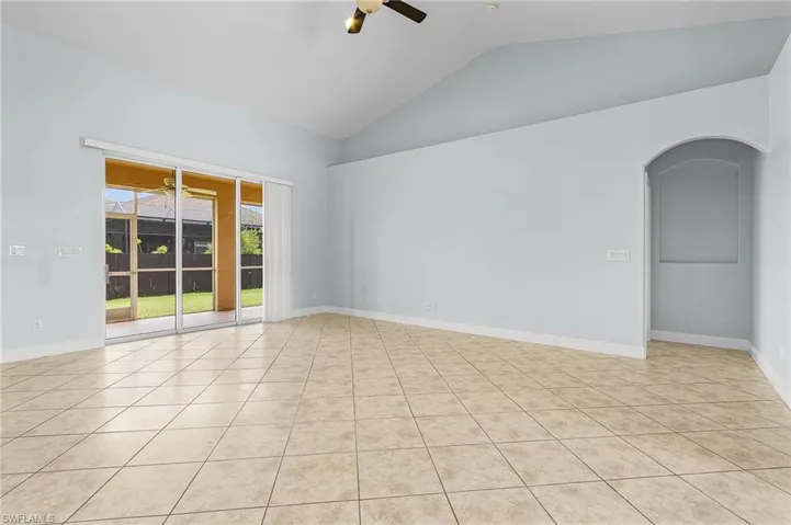Tiled great room with ceiling fan, cathderal ceiling, and triple 8' tall sliders to screened lanai.