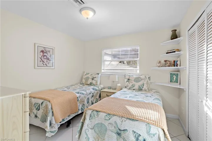 Bedroom with light tile patterned floors and a closet