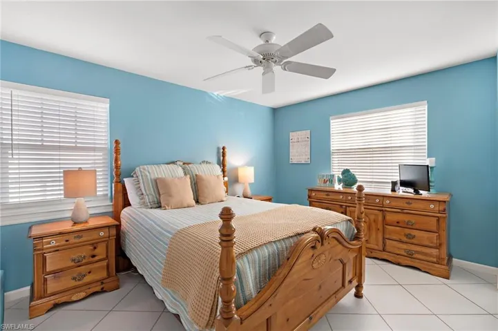 Bedroom with light tile patterned floors and ceiling fan