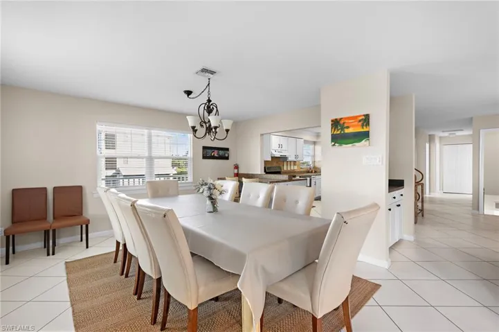 Tiled dining area featuring a notable chandelier