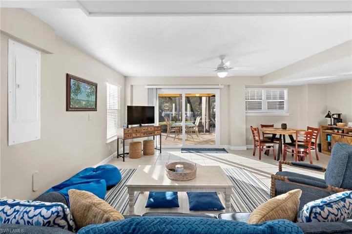 Living room featuring ceiling fan, light tile patterned floors, and electric panel