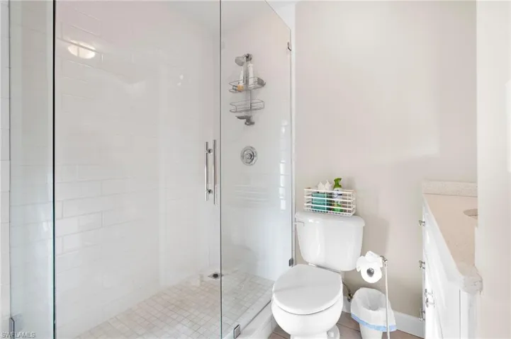 Bathroom with vanity, toilet, and a shower with door