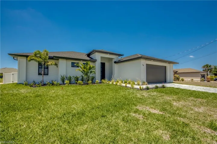 Prairie-style home with a garage, a front yard, and concrete driveway