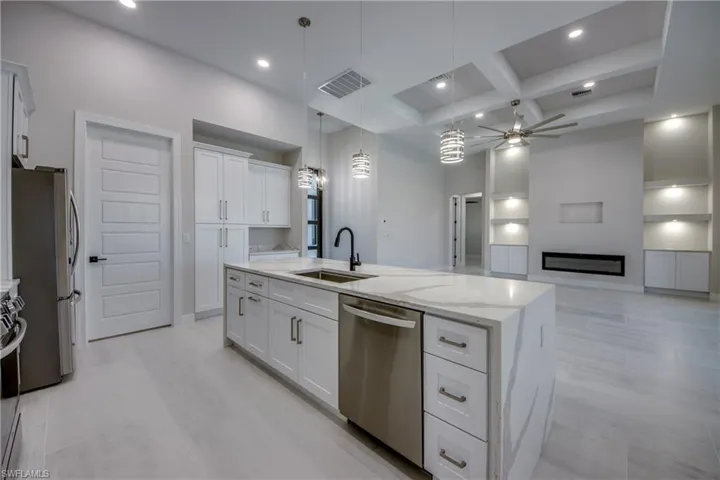 Kitchen with ceiling fan, a sink, stainless steel appliances, visible vents, and coffered ceiling
