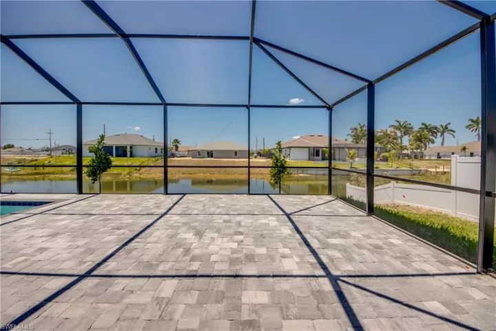View of patio featuring a water view, glass enclosure, and a residential view