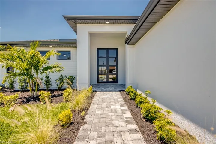 Doorway to property featuring french doors and stucco siding