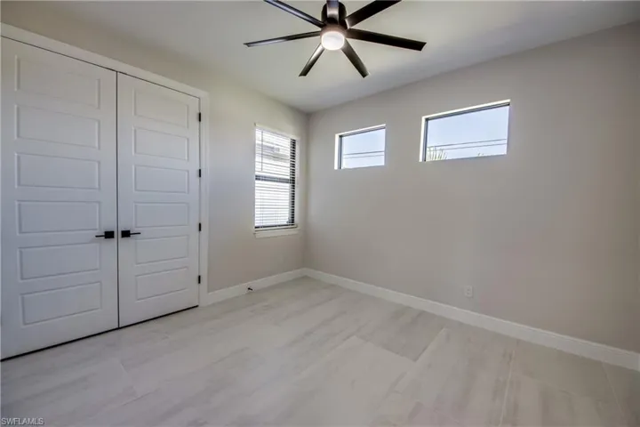 Unfurnished bedroom with a ceiling fan, baseboards, and a closet