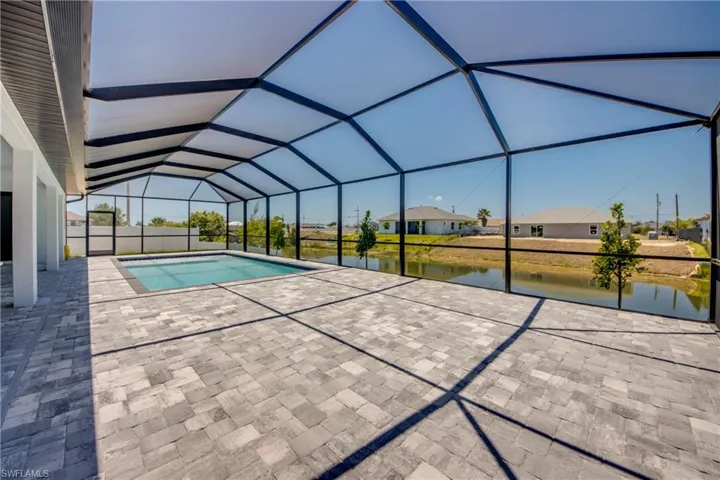 Outdoor pool featuring a patio, a water view, a lanai, and a residential view