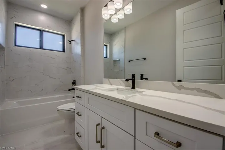 Full bath featuring toilet, a chandelier, tub / shower combination, and vanity