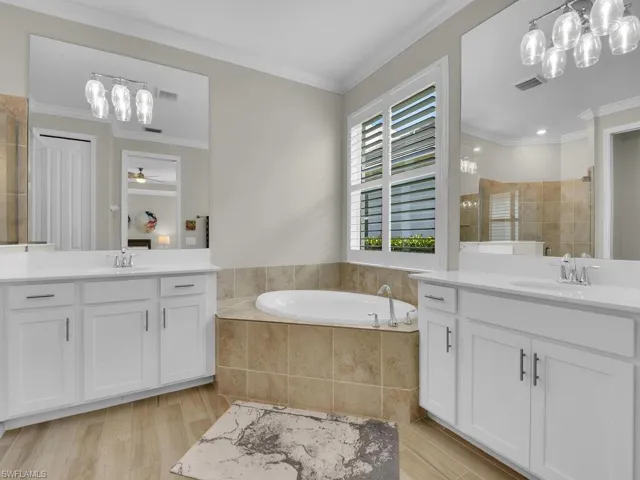 Elegant owner’s bath with separate vanities and a serene soaking tub