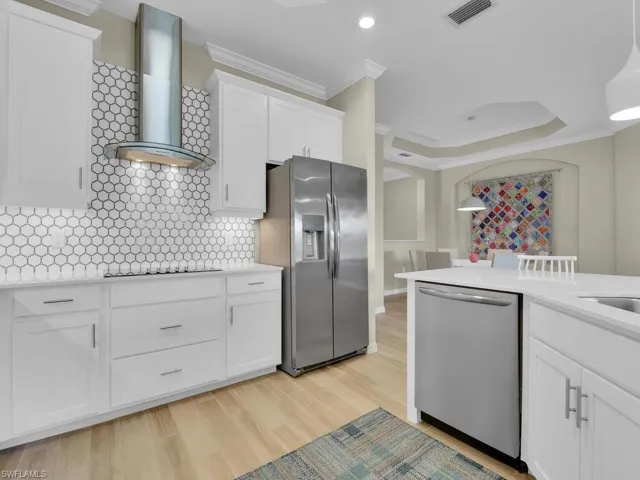 Sleek kitchen with custom tile backsplash and stainless steel appliances