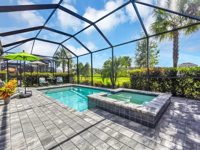Covered lanai features a hot tub and saltwater pool with golf course views