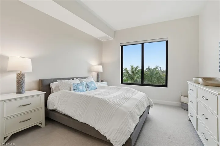 Bedroom featuring light carpet and baseboards