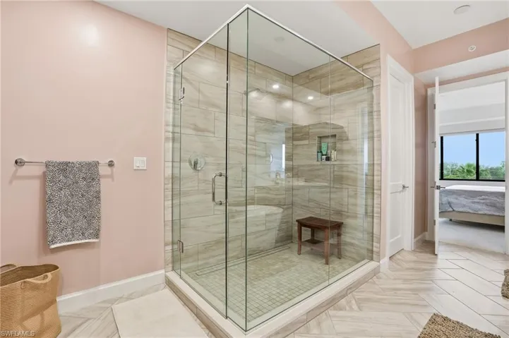 Ensuite bathroom featuring a shower stall and baseboards