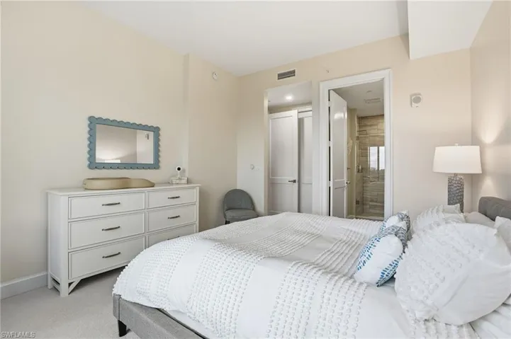 Bedroom with light carpet and ensuite bath