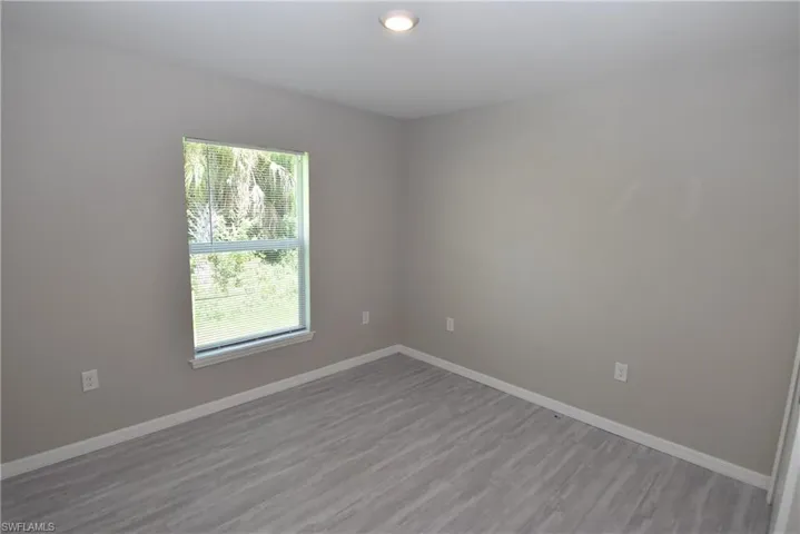 Spare room with baseboards and wood finished floors