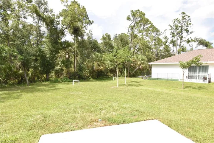View of grassy yard with view of scattered trees