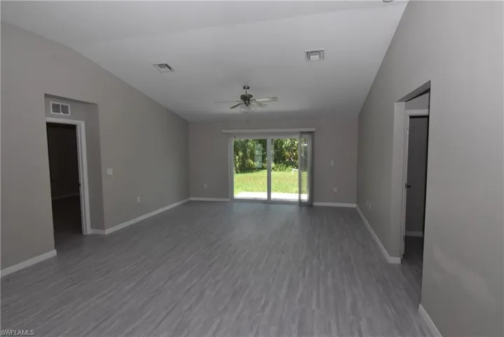 Spare room featuring vaulted ceiling, wood finished floors, and ceiling fan
