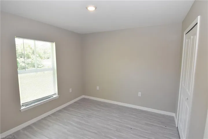 Unfurnished room with baseboards and light wood-type flooring