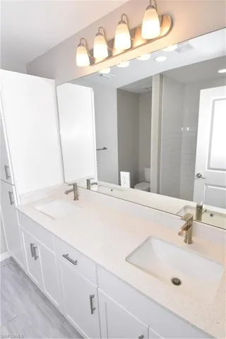 Bathroom featuring double vanity and light wood-style floors