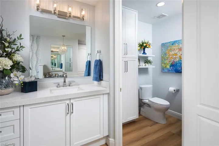 Bathroom featuring wood finished floors, vanity, a chandelier, and recessed lighting