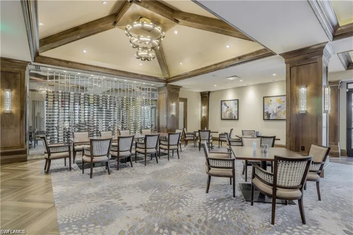 Dining area featuring decorative columns, beamed ceiling, crown molding, a chandelier, and high vaulted ceiling