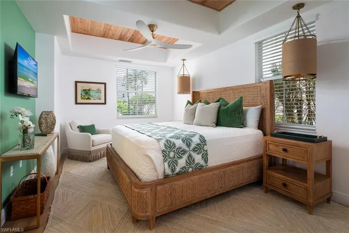Bedroom with wood accent tray ceiling, a ceiling fan, and wooden ceiling