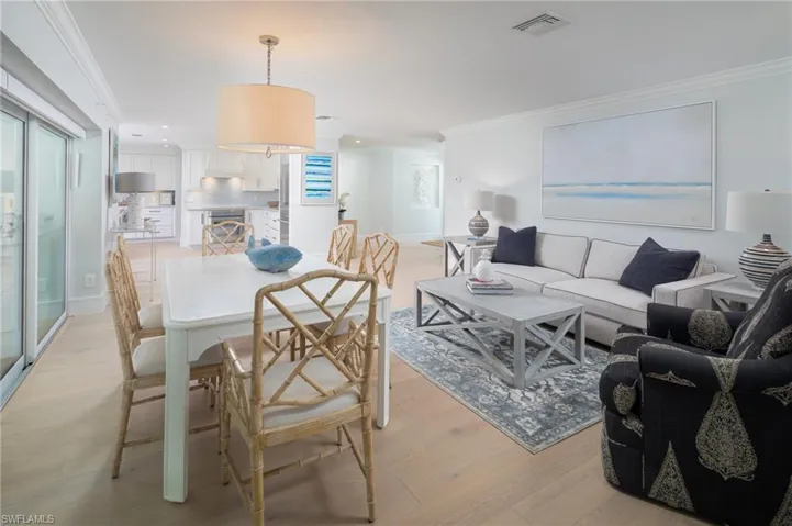 Dining room with crown molding, light wood-style flooring, and recessed lighting