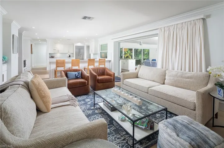 Living area with ornamental molding, a ceiling fan, and recessed lighting