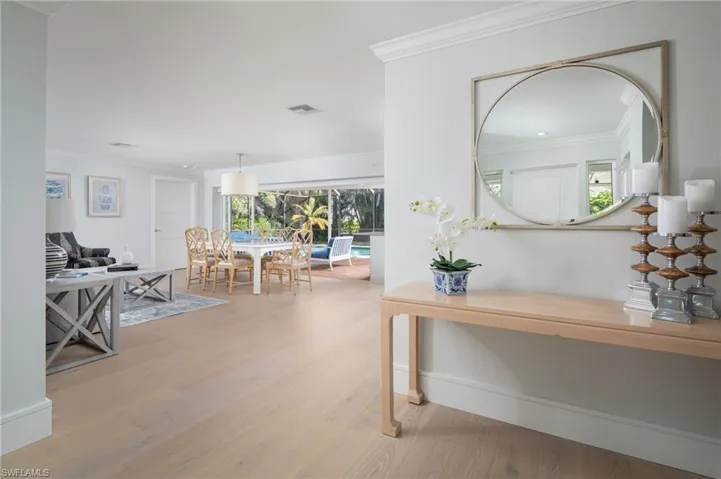 Corridor with crown molding and light wood-style floors