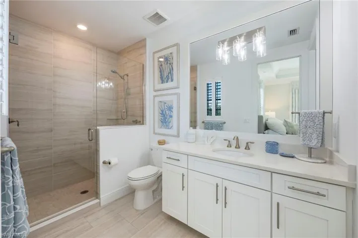 Ensuite bathroom featuring a shower stall and vanity